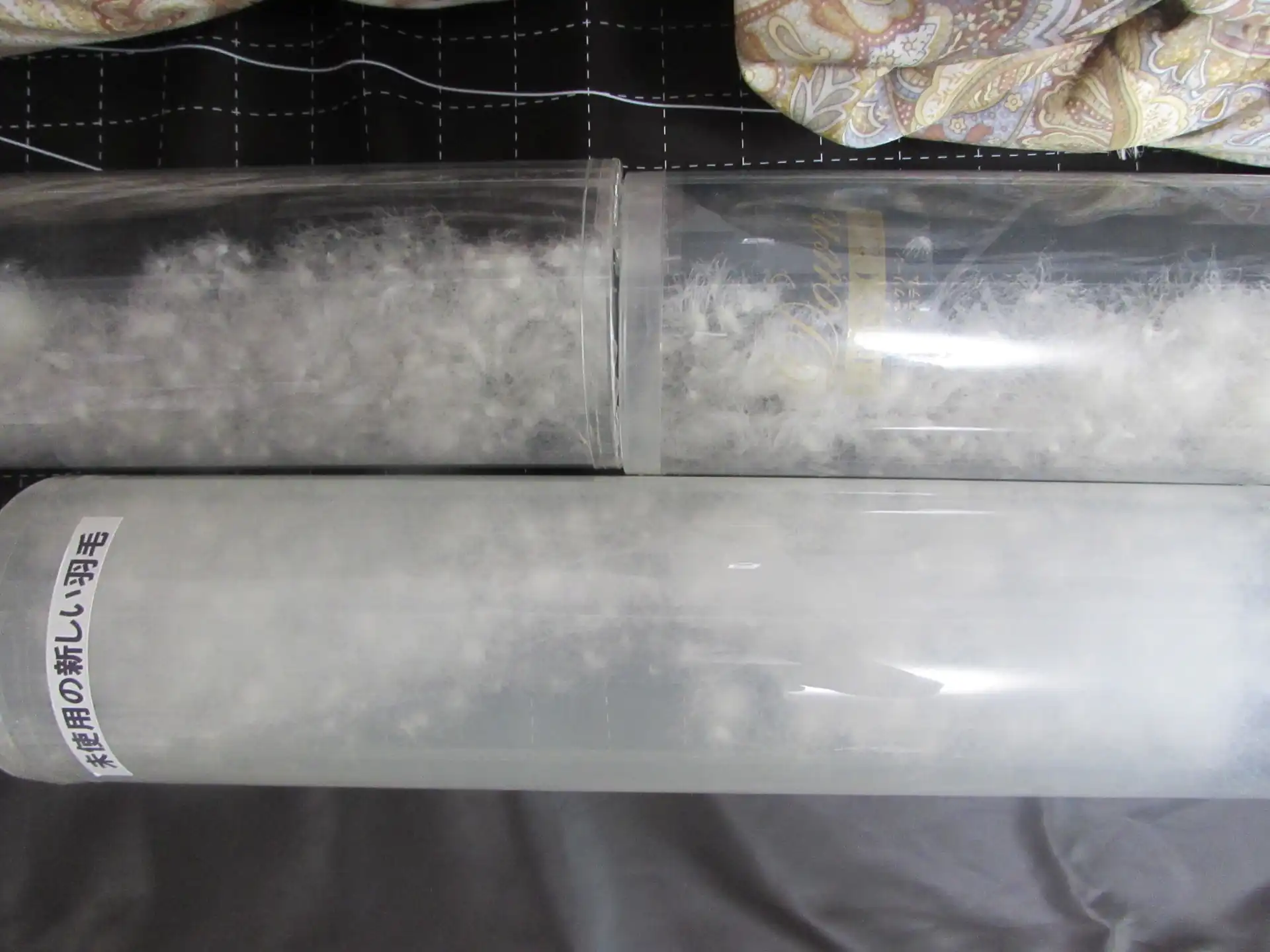 透明な筒に入った新しい羽毛と古い羽毛