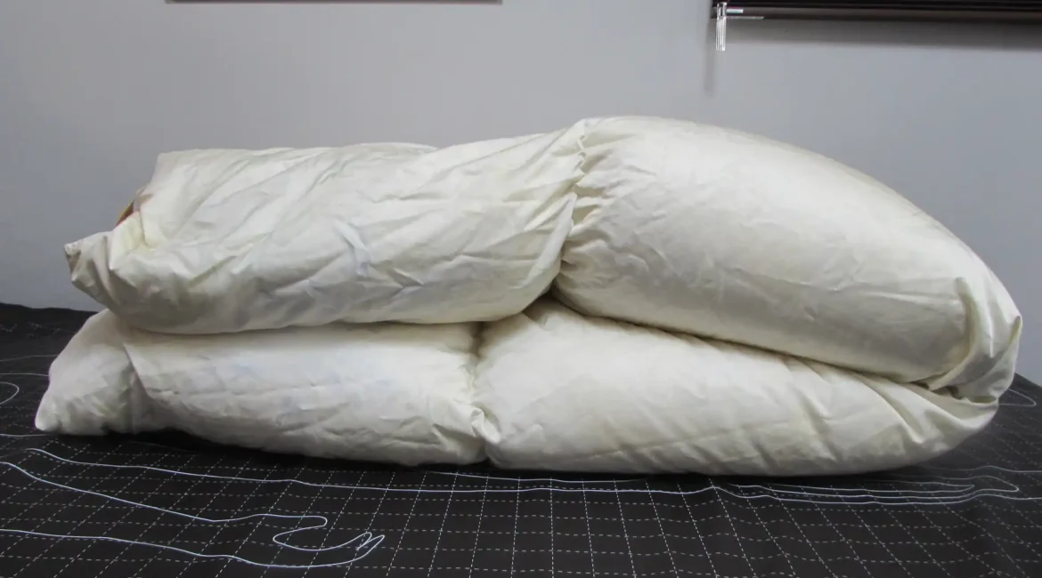 二つに折りたたまれた白い羽毛布団