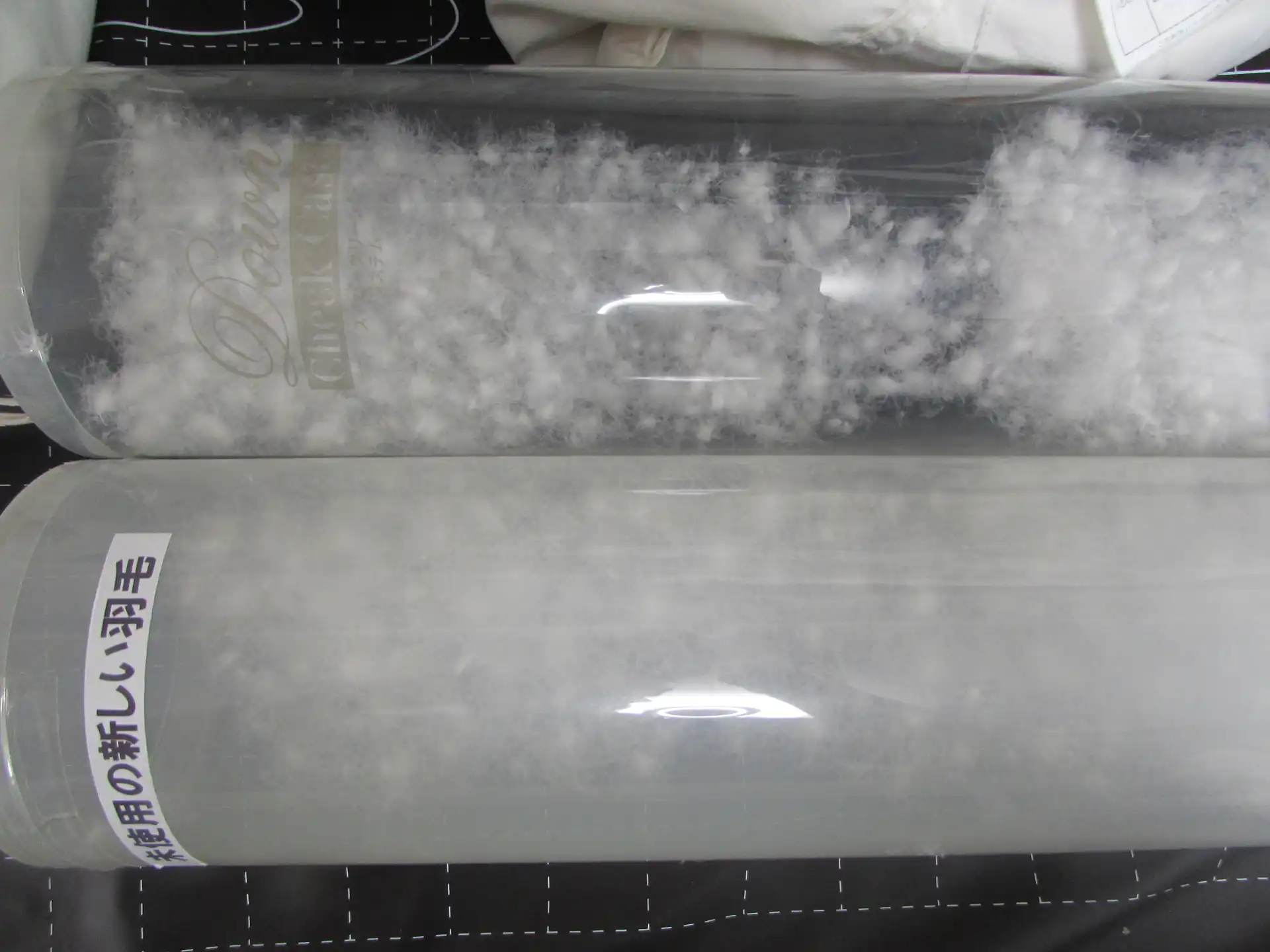 透明な筒に入った新しい羽毛と古い羽毛