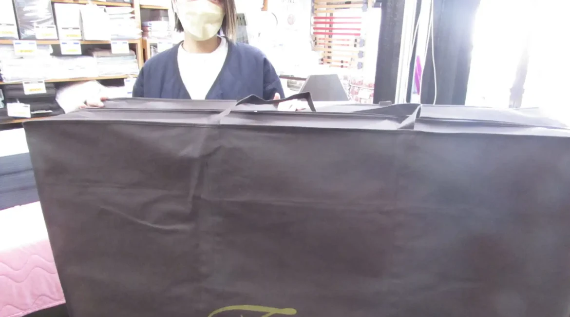 お試し貸し出しのマットレスを持つ女性