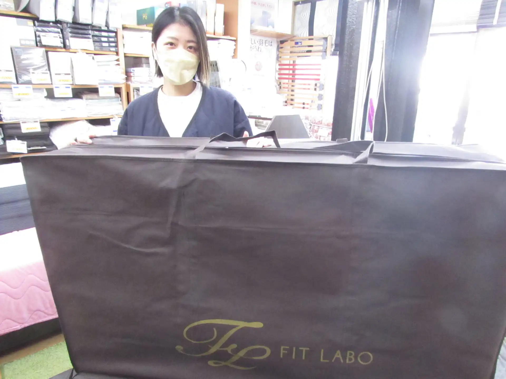 お試し貸し出しのマットレスを持つ女性